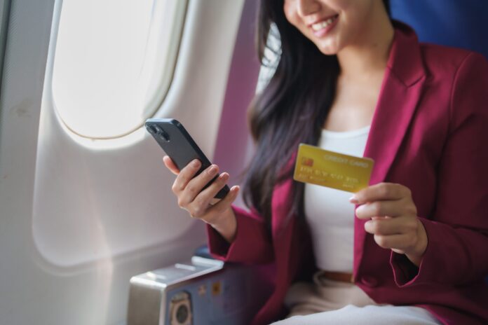 Smiling,Businesswoman,Using,Smartphone,And,Credit,Card,,Making,Online,Purchases